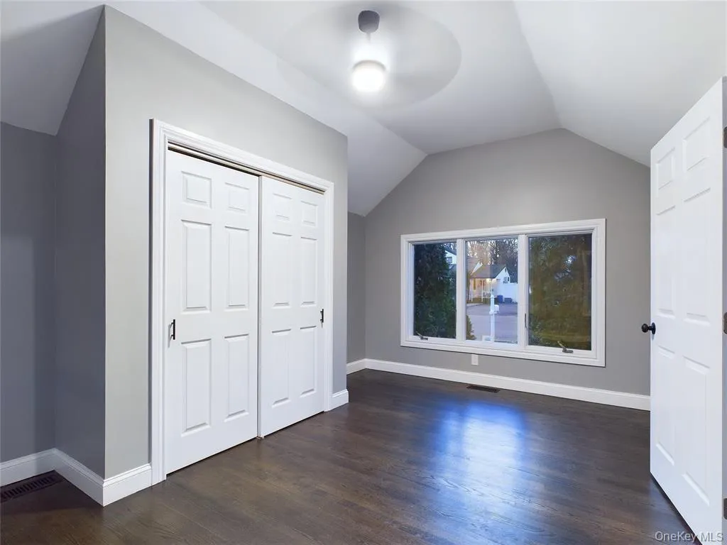 Additional living space with lofted ceiling and dark wood finished floors Additional living space with lofted ceiling and dark wood finished floors