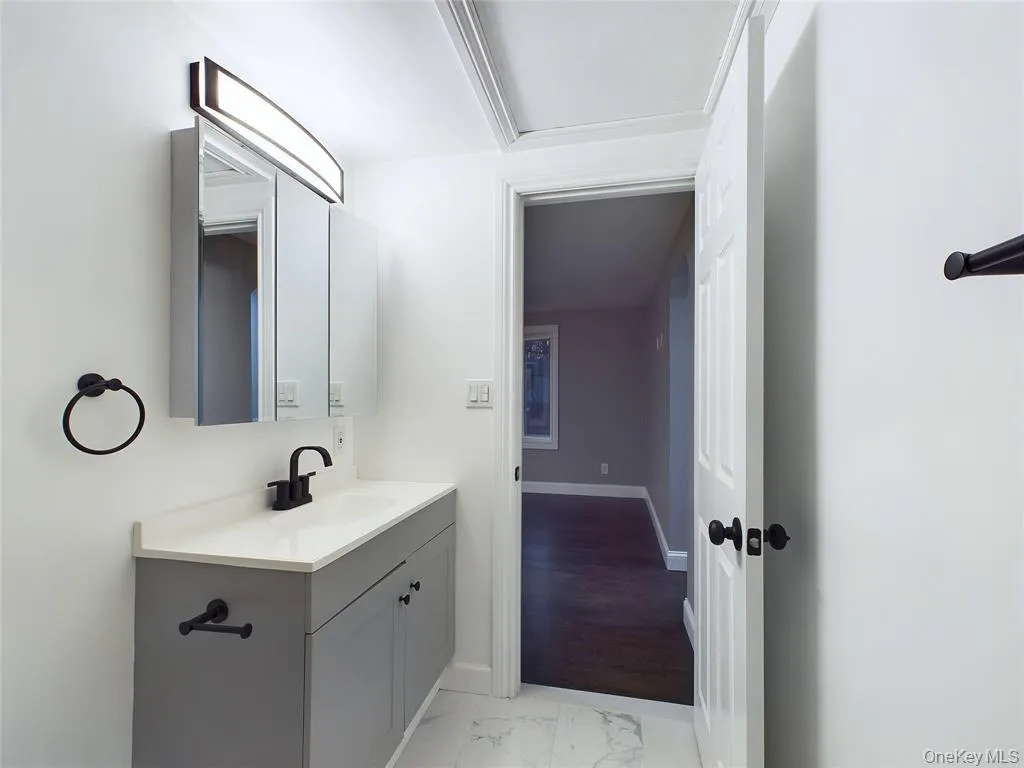 Bathroom featuring light marble finish flooring and vanity Bathroom featuring light marble finish flooring and vanity