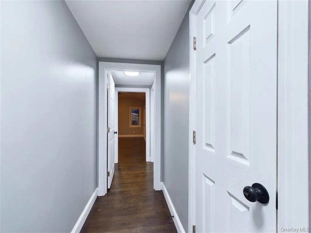 Hall featuring baseboards and dark wood finished floors Hall featuring baseboards and dark wood finished floors