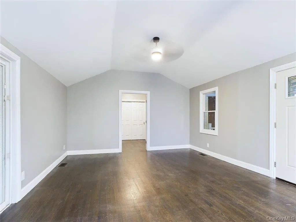 Additional living space featuring vaulted ceiling and dark wood-style flooring Additional living space featuring vaulted ceiling and dark wood-style flooring