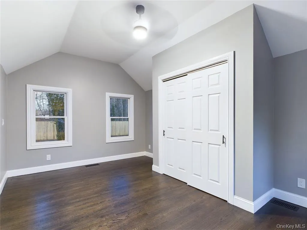Unfurnished bedroom featuring vaulted ceiling, dark wood-style flooring, a closet, and ceiling fan Unfurnished bedroom featuring vaulted ceiling, dark wood-style flooring, a closet, and ceiling fan