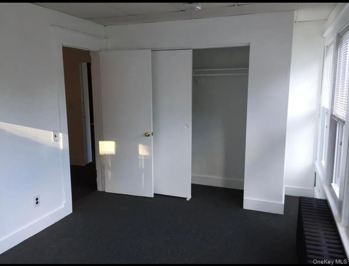 Unfurnished bedroom with a closet and a drop ceiling Unfurnished bedroom with a closet and a drop ceiling