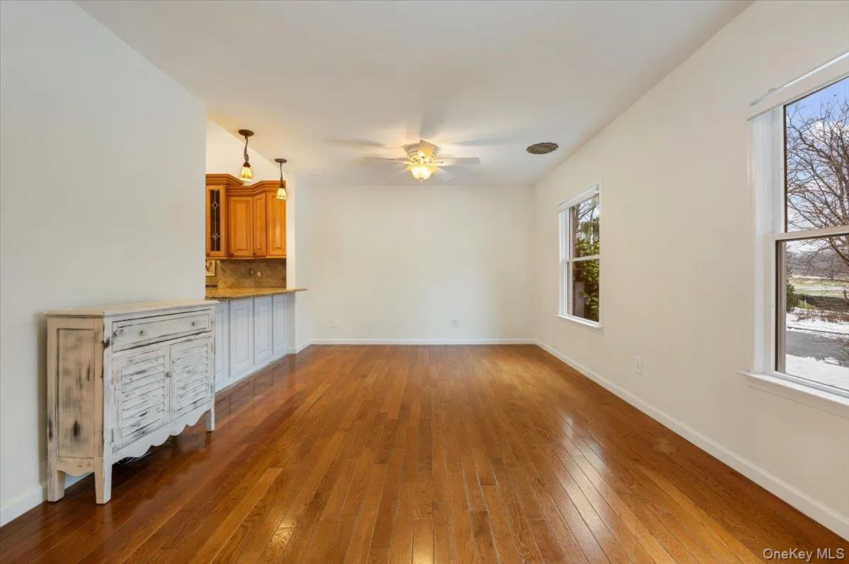 Unfurnished living room with hardwood / wood-style flooring and ceiling fan Unfurnished living room with hardwood / wood-style flooring and ceiling fan