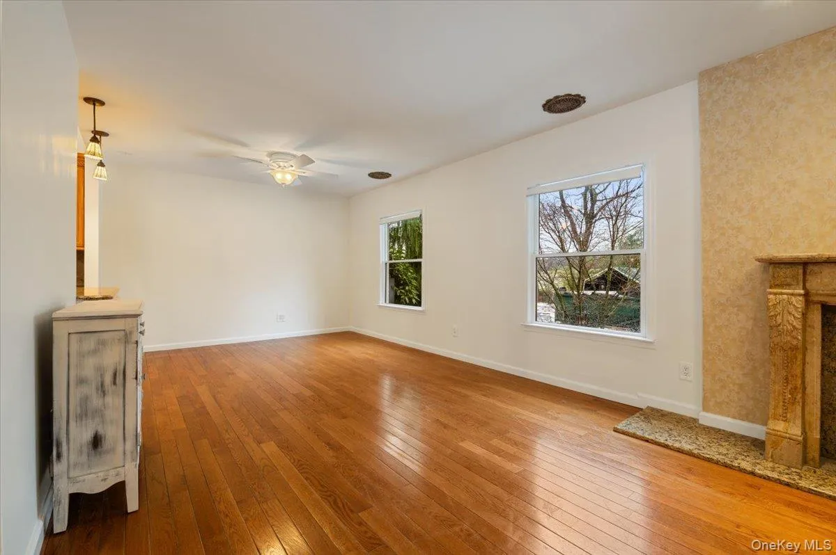 Unfurnished living room with light wood-style flooring and a ceiling fan Unfurnished living room with light wood-style flooring and a ceiling fan