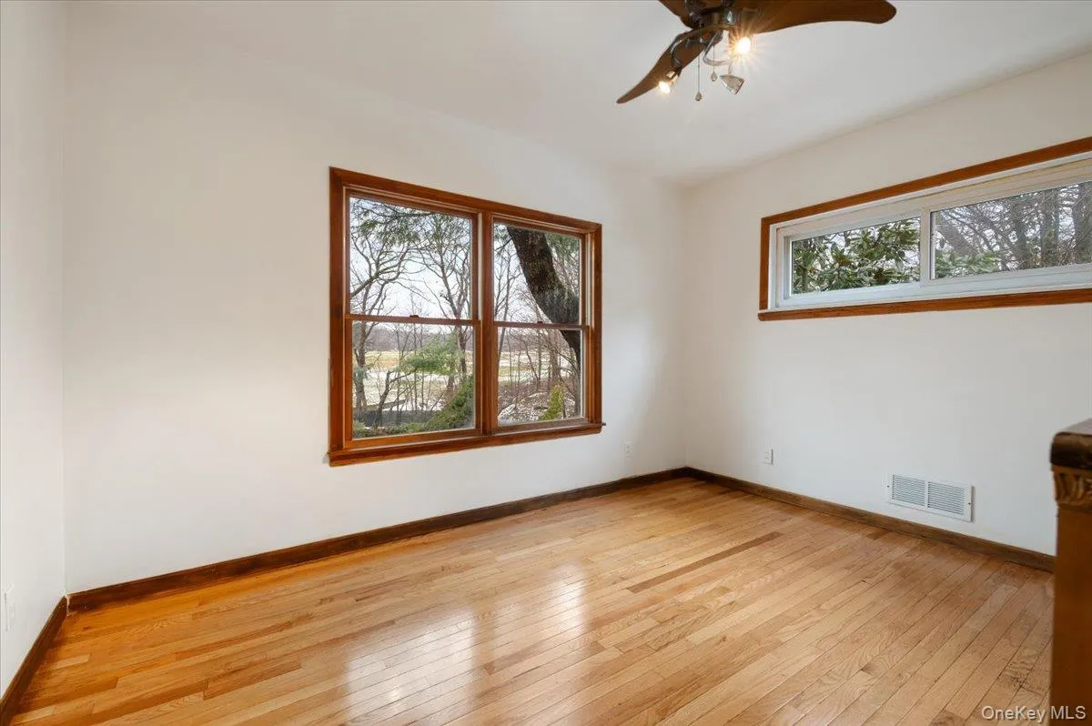 Spare room with a ceiling fan, healthy amount of natural light, and light wood-style flooring Spare room with a ceiling fan, healthy amount of natural light, and light wood-style flooring