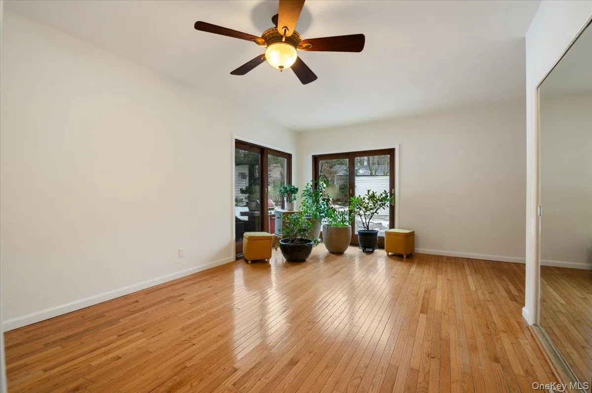 Living area featuring light wood-style floors and ceiling fan Living area featuring light wood-style floors and ceiling fan