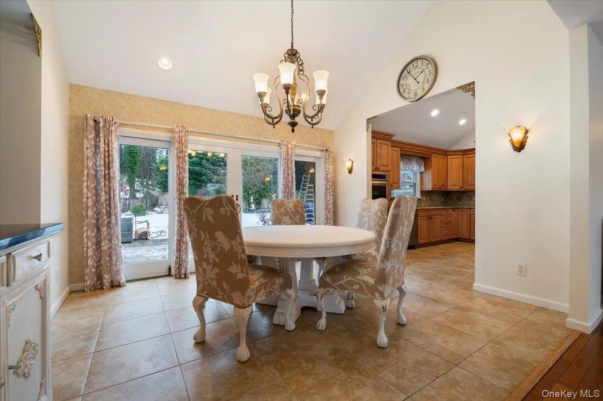 Dining room featuring light tile patterned floors, high vaulted ceiling, recessed lighting, and a chandelier Dining room featuring light tile patterned floors, high vaulted ceiling, recessed lighting, and a chandelier