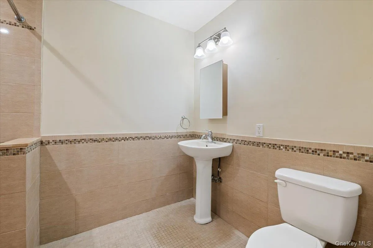 Bathroom featuring a wainscoted wall and tile walls Bathroom featuring a wainscoted wall and tile walls
