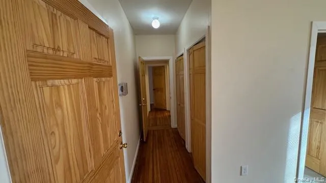 Bedroom Hallway with dark wood-style floors and baseboards Bedroom Hallway with dark wood-style floors and baseboards