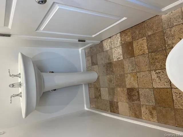 Powder room featuring baseboards and stone tile flooring Powder room featuring baseboards and stone tile flooring