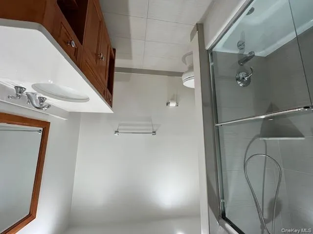 Hall Bathroom featuring combined bath / shower with glass door, light tile patterned flooring, and vanity Hall Bathroom featuring combined bath / shower with glass door, light tile patterned flooring, and vanity