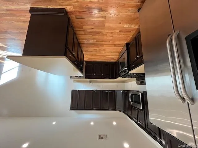 Kitchen featuring fridge, stainless steel range oven, a kitchen island, recessed lighting, and light wood-style floors Kitchen featuring fridge, stainless steel range oven, a kitchen island, recessed lighting, and light wood-style floors