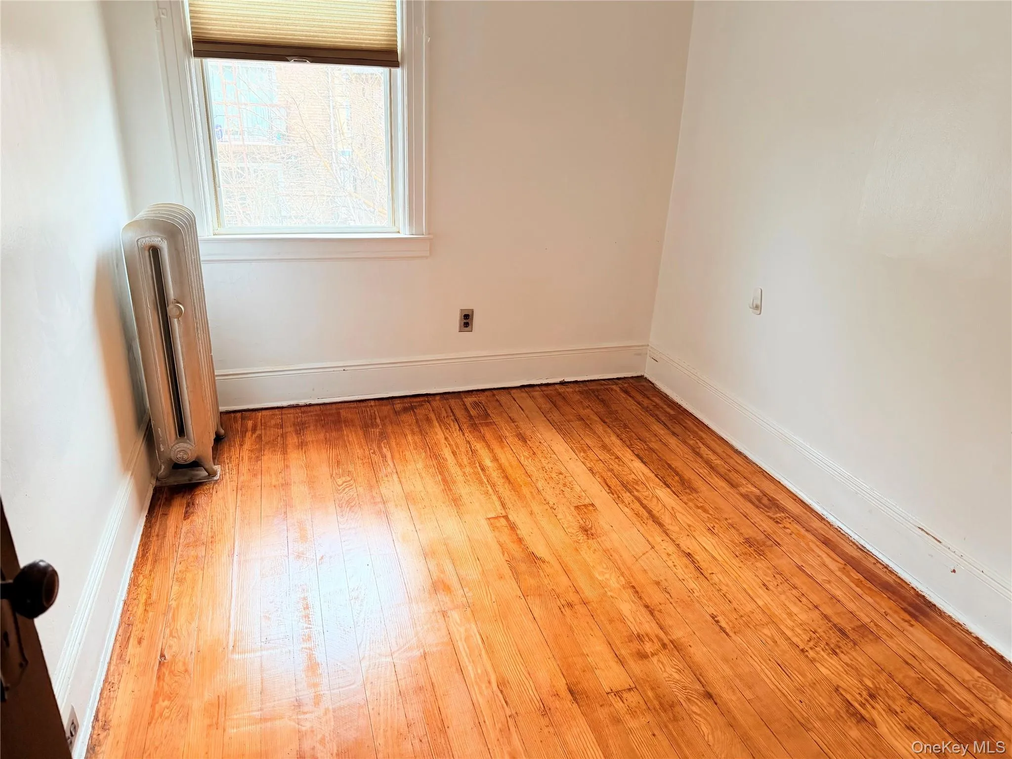 Spare room featuring radiator and light wood-type flooring Spare room featuring radiator and light wood-type flooring