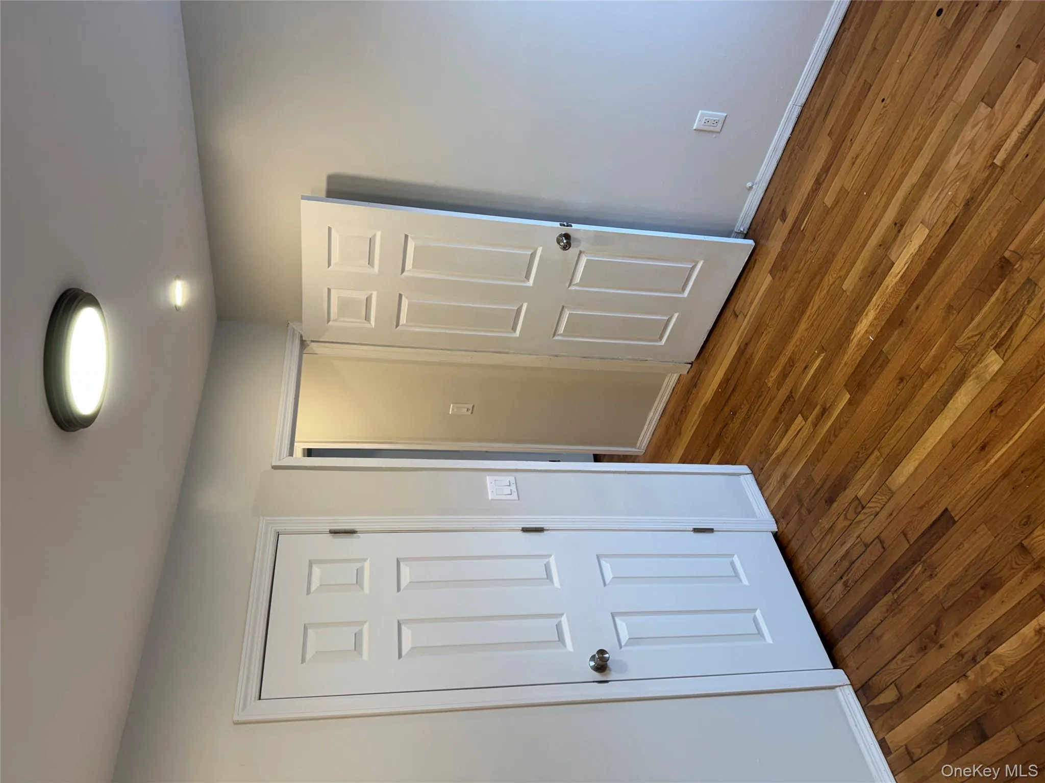 Unfurnished bedroom with dark wood-type flooring and baseboards Unfurnished bedroom with dark wood-type flooring and baseboards