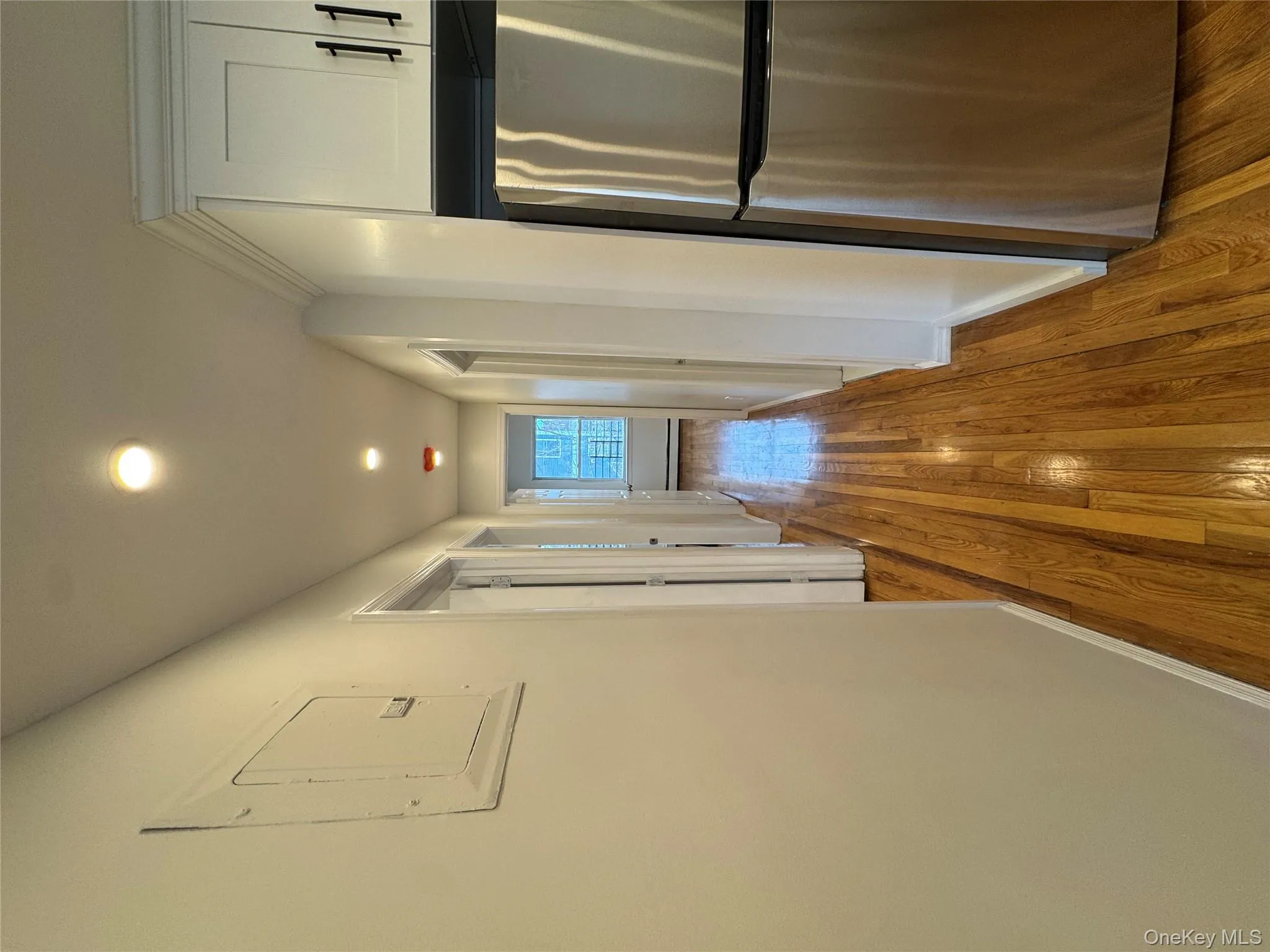 Corridor with light wood-style floors, electric panel, and recessed lighting Corridor with light wood-style floors, electric panel, and recessed lighting