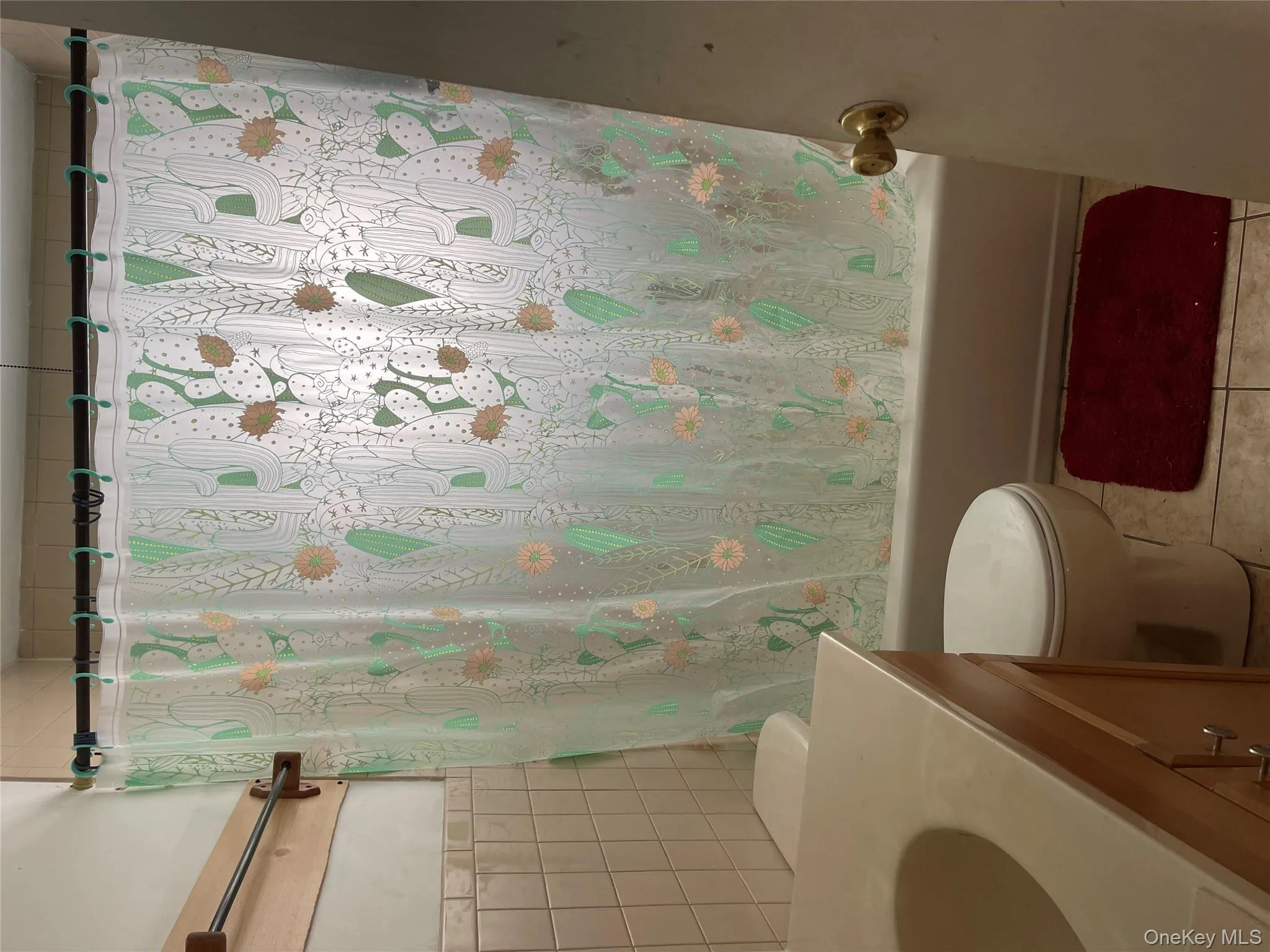 Full bathroom with vanity, light tile patterned floors, shower / tub combo, and tile walls Full bathroom with vanity, light tile patterned floors, shower / tub combo, and tile walls