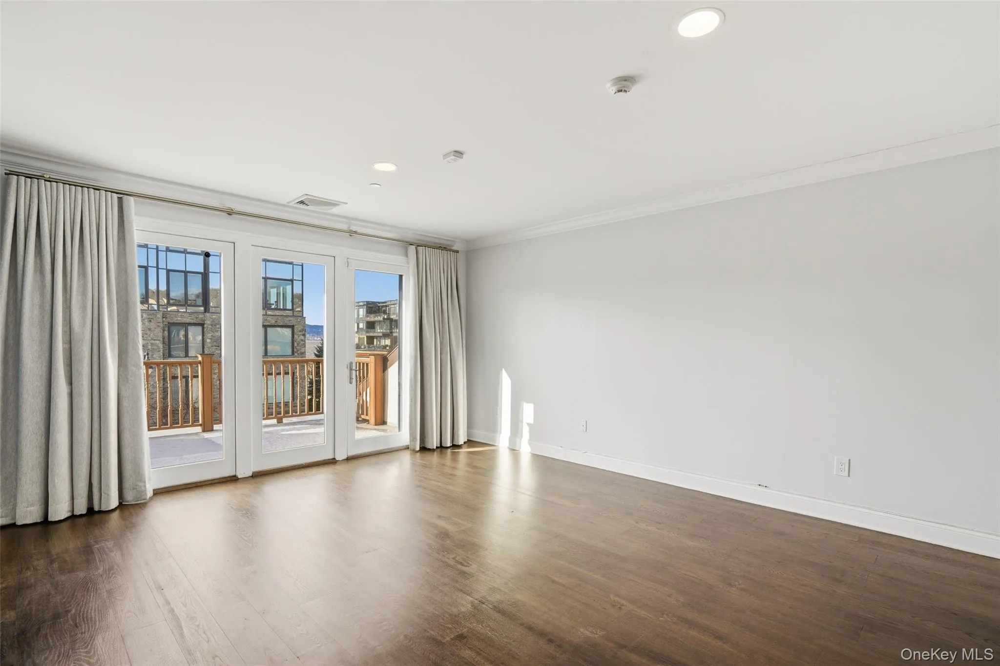 Unfurnished room with recessed lighting, crown molding, and dark wood finished floors Unfurnished room with recessed lighting, crown molding, and dark wood finished floors