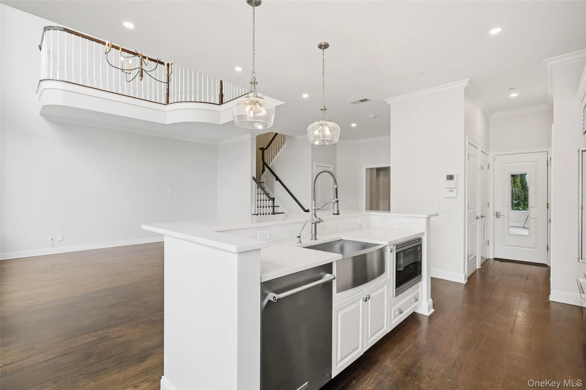 Kitchen featuring stainless steel dishwasher, pendant lighting, white cabinets, an island with sink, and recessed lighting Kitchen featuring stainless steel dishwasher, pendant lighting, white cabinets, an island with sink, and recessed lighting