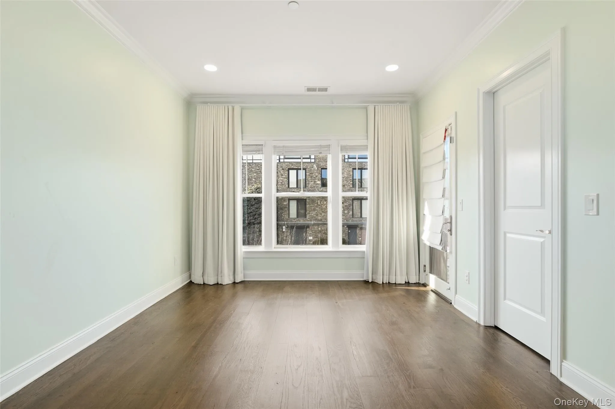 Empty room featuring crown molding, dark wood-style flooring, and recessed lighting Empty room featuring crown molding, dark wood-style flooring, and recessed lighting