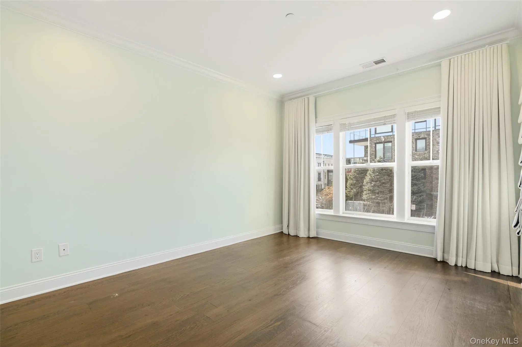 Spare room featuring crown molding, dark wood-style flooring, and recessed lighting Spare room featuring crown molding, dark wood-style flooring, and recessed lighting