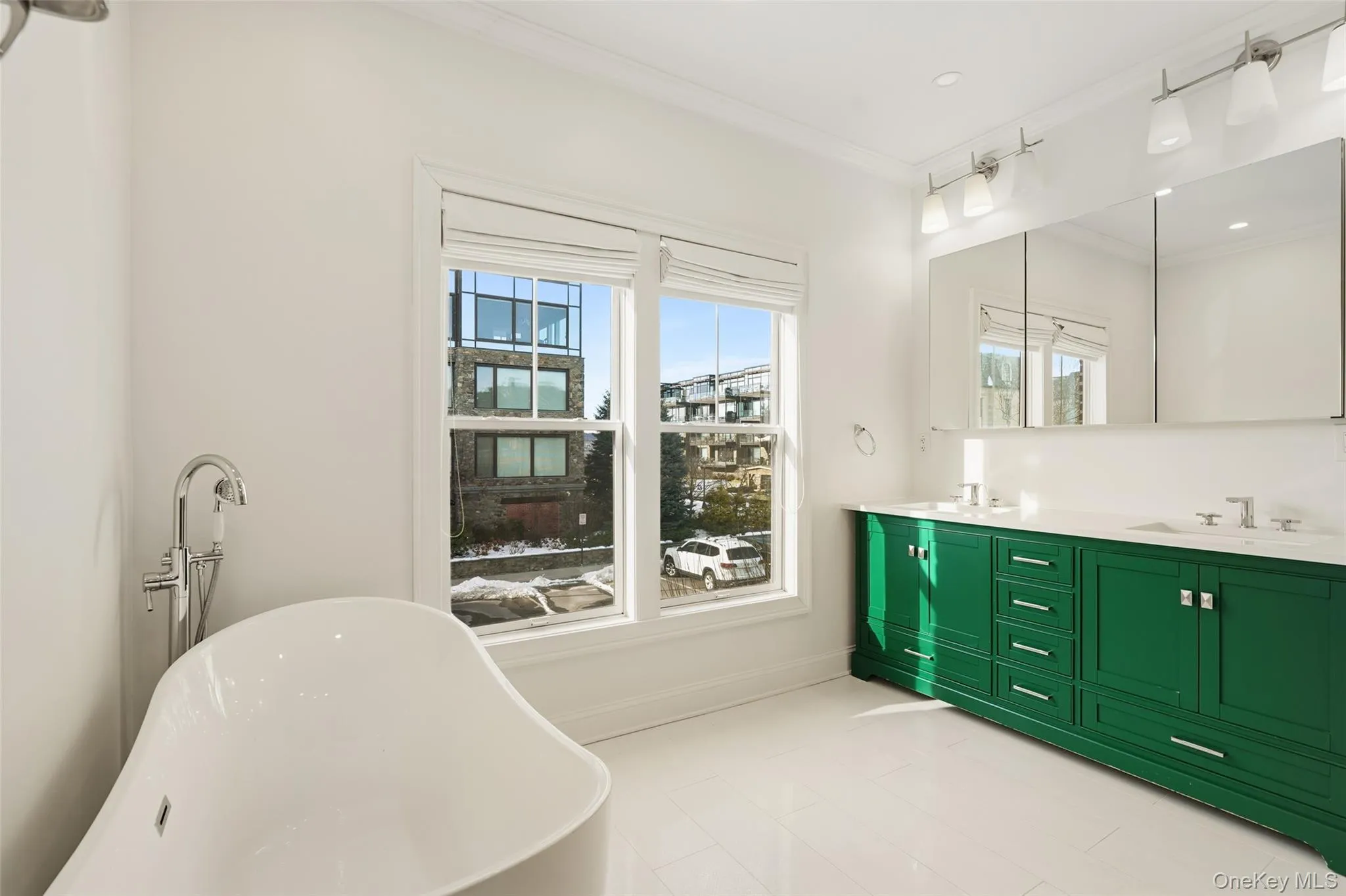 Full bathroom featuring double vanity, a freestanding tub, healthy amount of natural light, and crown molding Full bathroom featuring double vanity, a freestanding tub, healthy amount of natural light, and crown molding