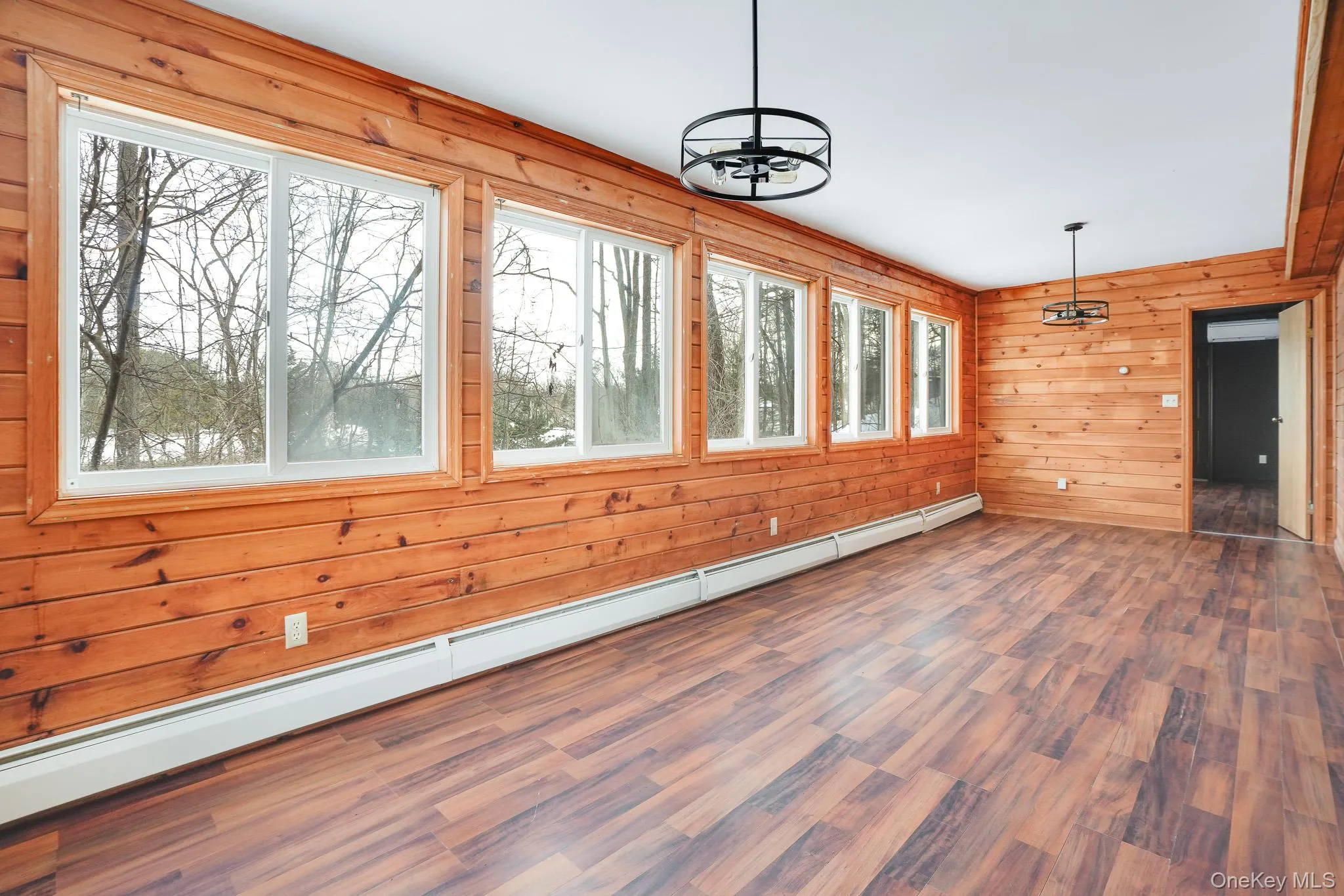 Unfurnished sunroom with a baseboard radiator and a chandelier Unfurnished sunroom with a baseboard radiator and a chandelier