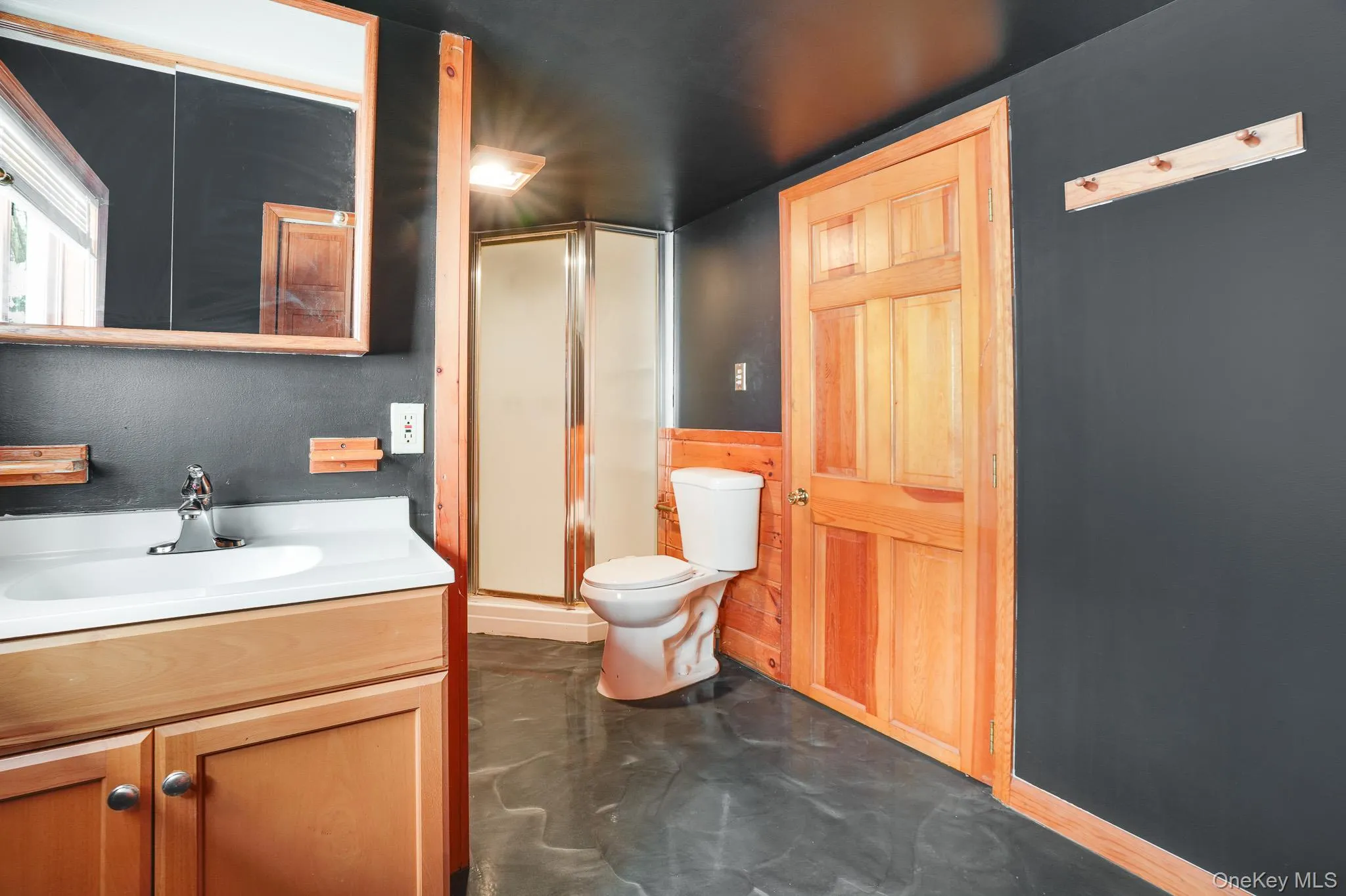 Full bathroom featuring a shower stall, concrete flooring, and vanity Full bathroom featuring a shower stall, concrete flooring, and vanity