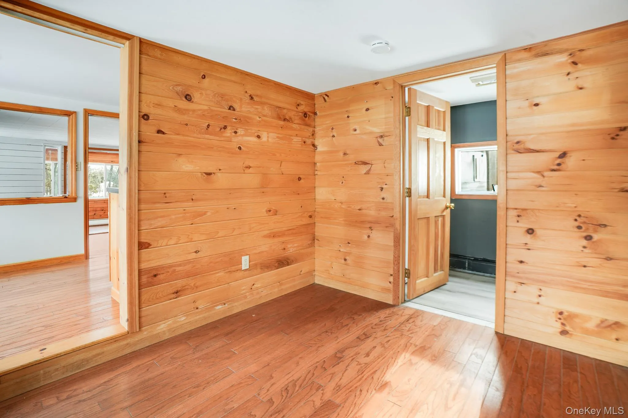 Empty room featuring light wood finished floors and wooden walls Empty room featuring light wood finished floors and wooden walls
