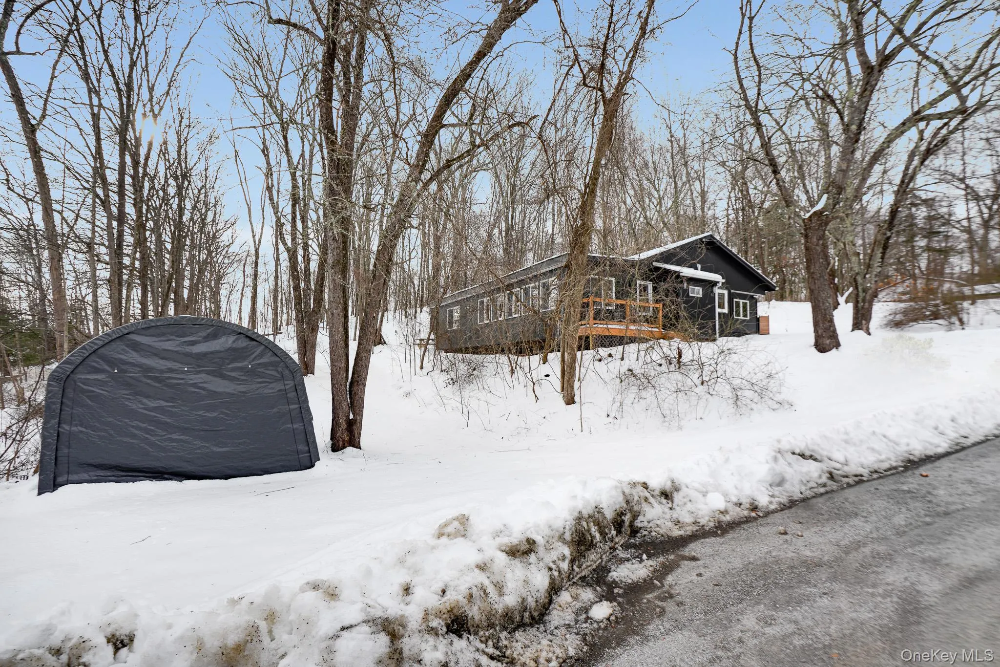 Yard covered in snow with a wooden deck Yard covered in snow with a wooden deck