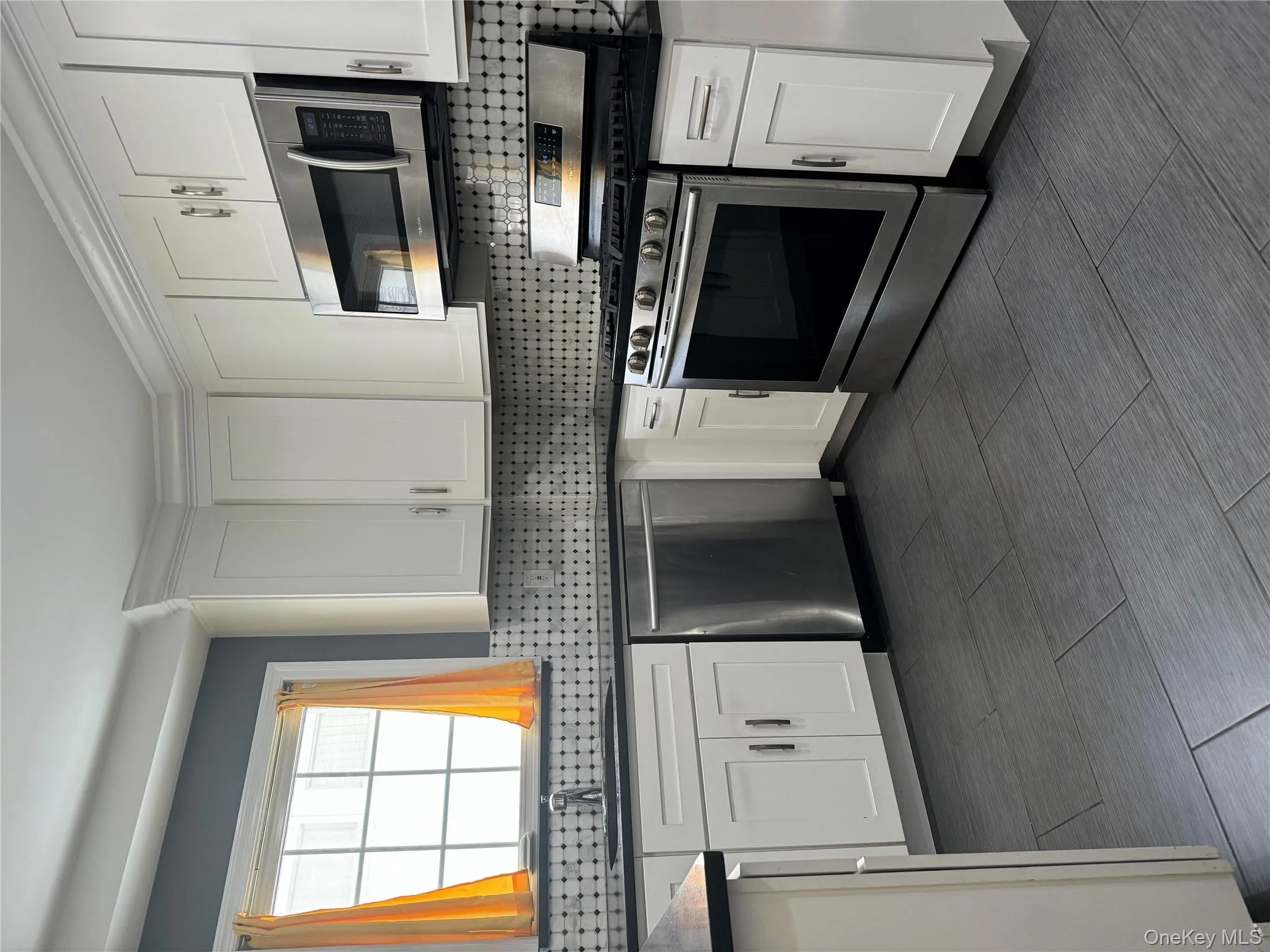 Kitchen featuring appliances with stainless steel finishes, white cabinetry, and tasteful backsplash Kitchen featuring appliances with stainless steel finishes, white cabinetry, and tasteful backsplash