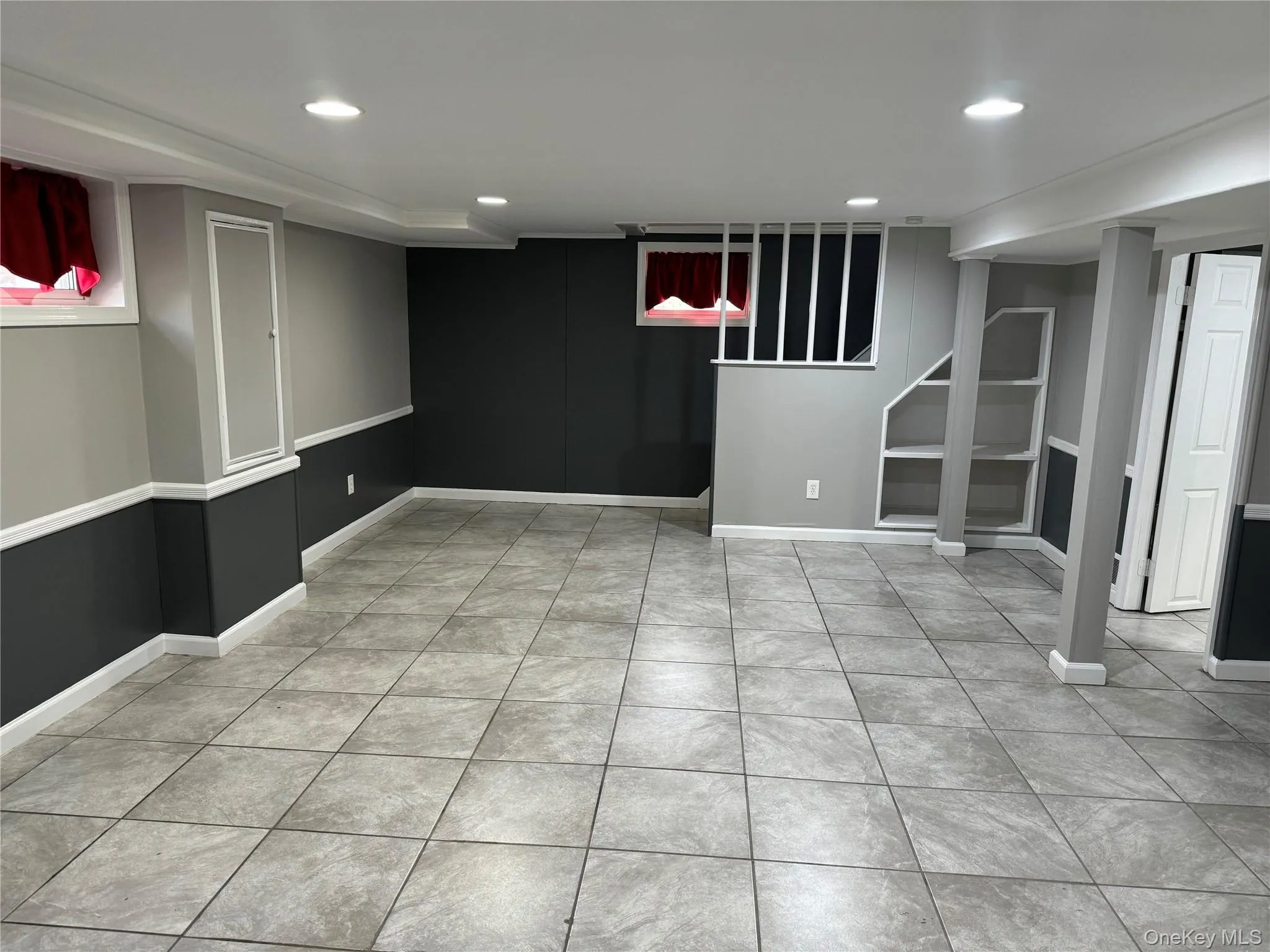 Finished basement with recessed lighting and light tile patterned floors Finished basement with recessed lighting and light tile patterned floors
