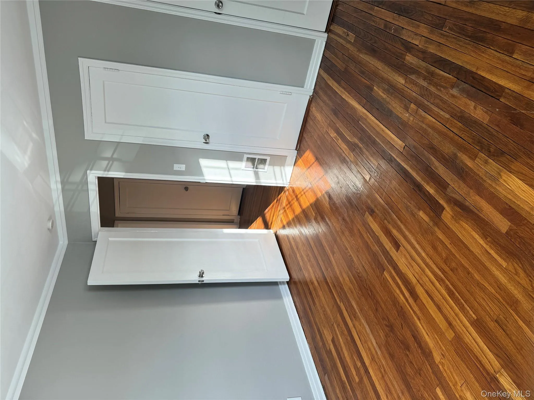 Unfurnished bedroom featuring crown molding and dark wood-type flooring Unfurnished bedroom featuring crown molding and dark wood-type flooring