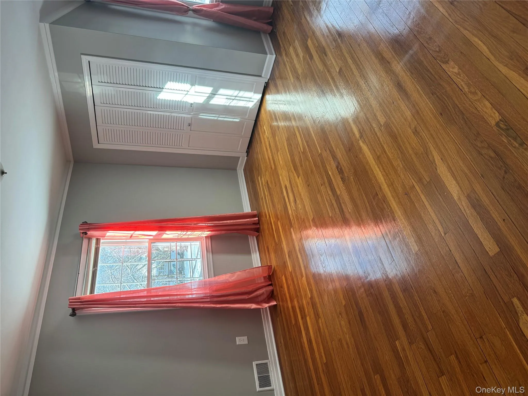 Unfurnished bedroom with ornamental molding, wood-type flooring, and a closet Unfurnished bedroom with ornamental molding, wood-type flooring, and a closet