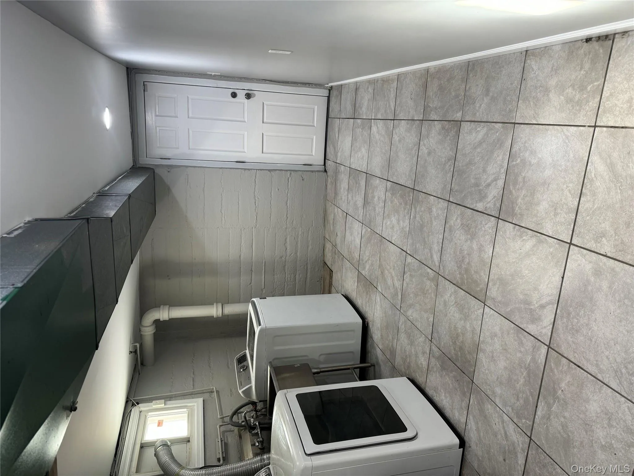 Laundry room featuring washing machine and clothes dryer and light tile patterned floors Laundry room featuring washing machine and clothes dryer and light tile patterned floors