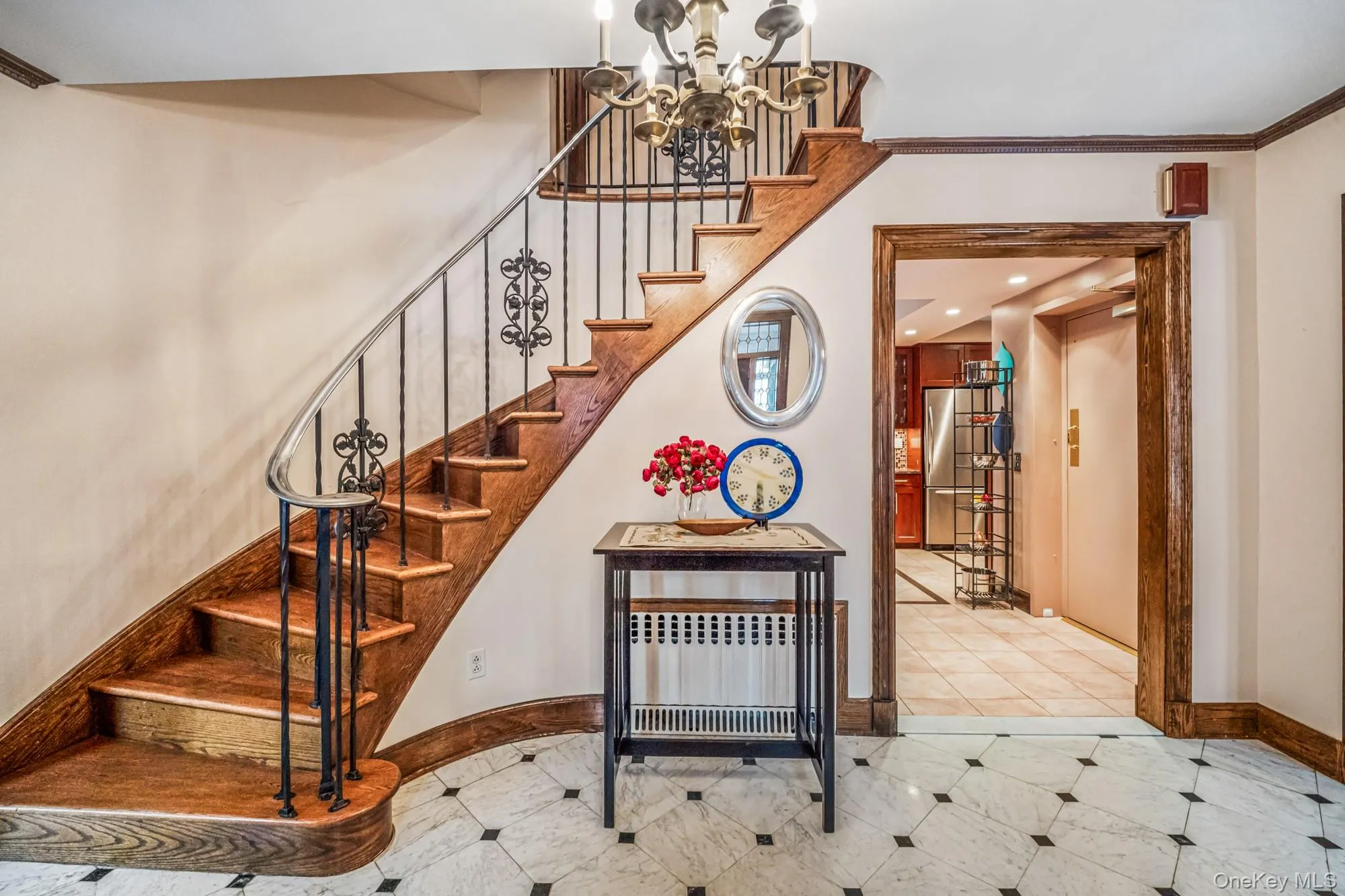 Staircase featuring a chandelier, crown molding, and elevator Staircase featuring a chandelier, crown molding, and elevator