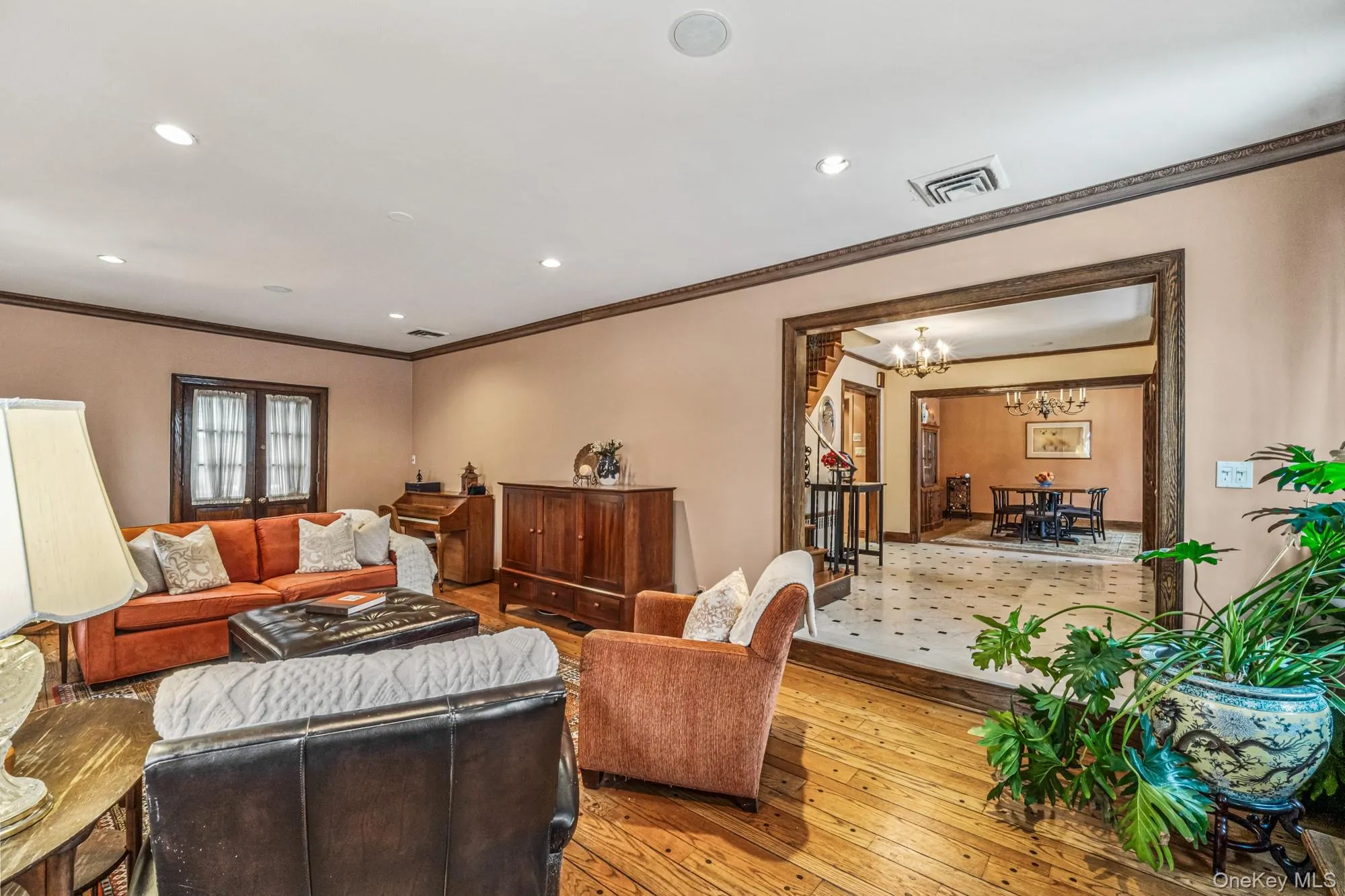 Living area featuring crown molding, hardwood / wood-style flooring, recessed lighting, stairs, and a chandelier Living area featuring crown molding, hardwood / wood-style flooring, recessed lighting, stairs, and a chandelier
