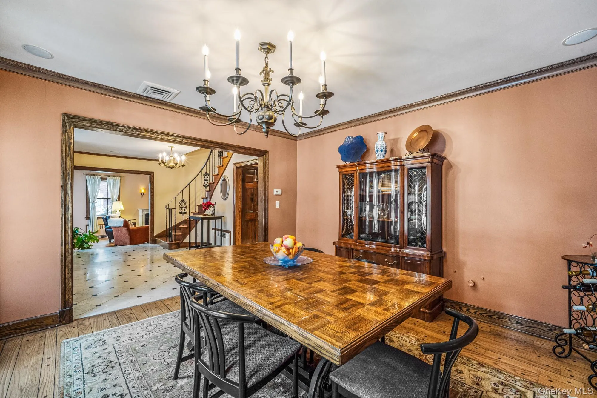 Dining area featuring a chandelier, stairs, light wood-style flooring, and ornamental molding Dining area featuring a chandelier, stairs, light wood-style flooring, and ornamental molding