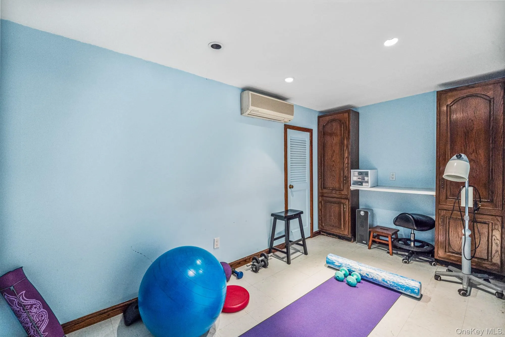 Exercise room with tile patterned floors, a wall mounted AC, and recessed lighting Exercise room with tile patterned floors, a wall mounted AC, and recessed lighting