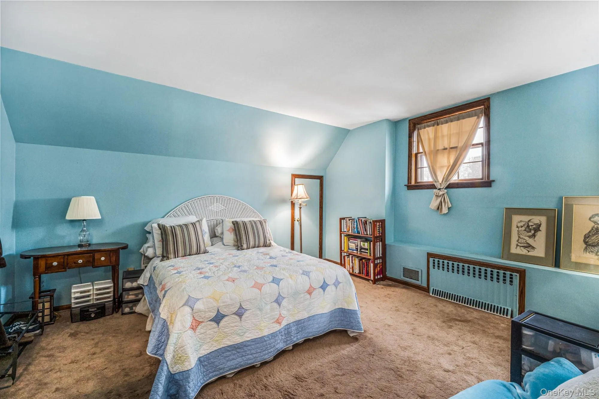 Bedroom featuring radiator, carpet, and lofted ceiling Bedroom featuring radiator, carpet, and lofted ceiling