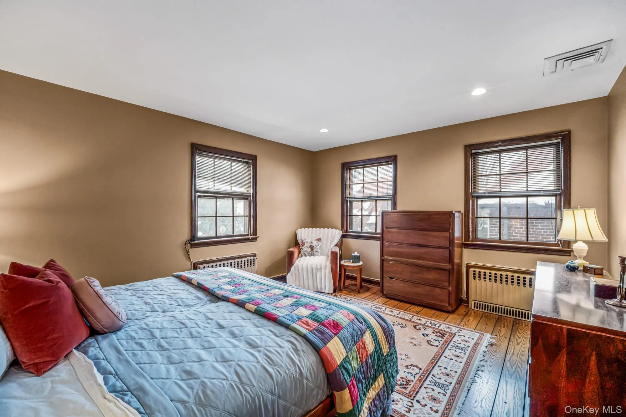Bedroom featuring radiator heating unit, wood-type flooring, and recessed lighting Bedroom featuring radiator heating unit, wood-type flooring, and recessed lighting