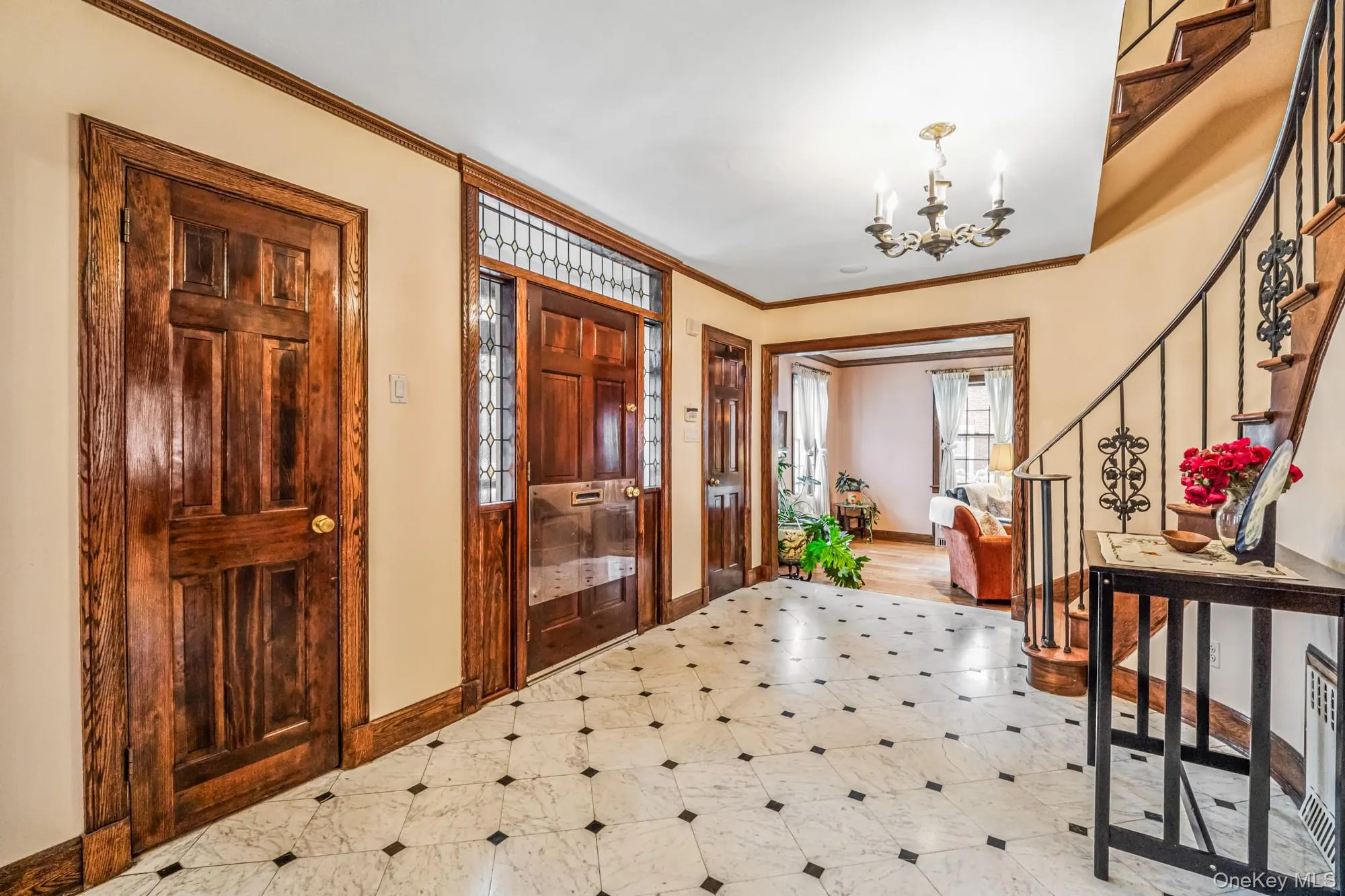 Entryway with stairway, ornamental molding, a chandelier, and light flooring Entryway with stairway, ornamental molding, a chandelier, and light flooring