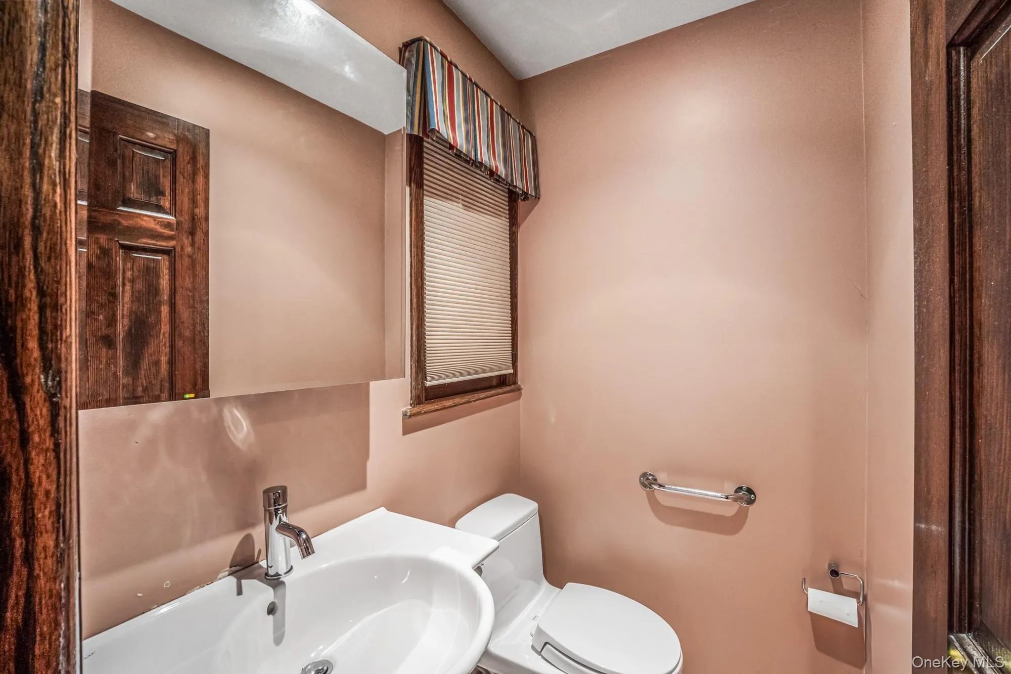 Half bath featuring toilet and a sink Half bath featuring toilet and a sink