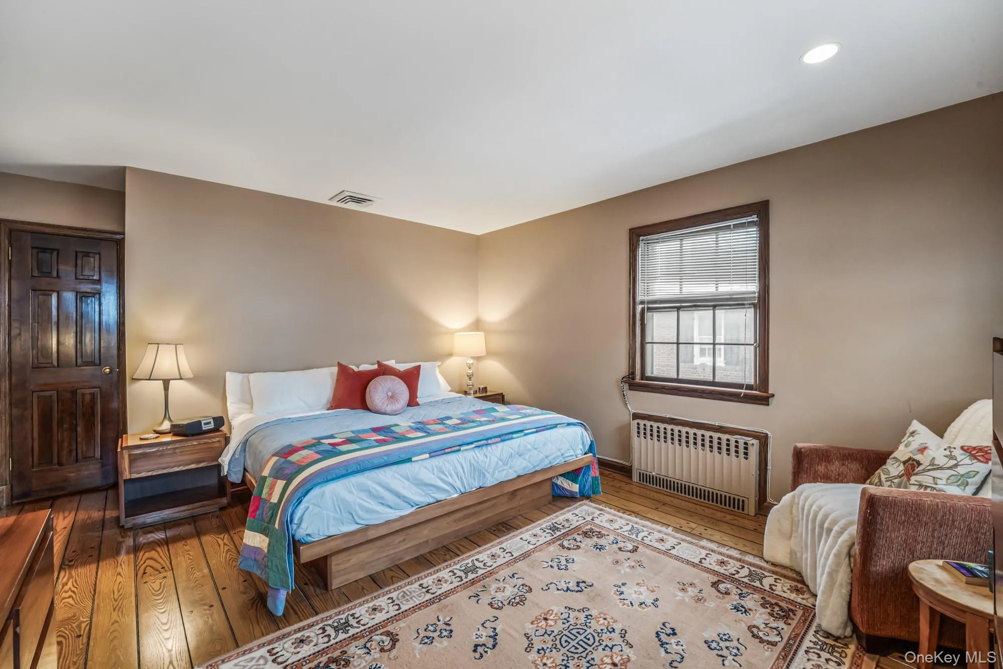 Bedroom featuring radiator and wood-type flooring Bedroom featuring radiator and wood-type flooring