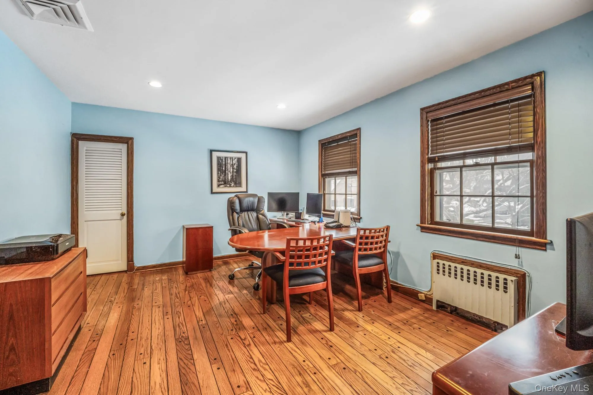 Office space with radiator, light wood-style floors, and recessed lighting Office space with radiator, light wood-style floors, and recessed lighting
