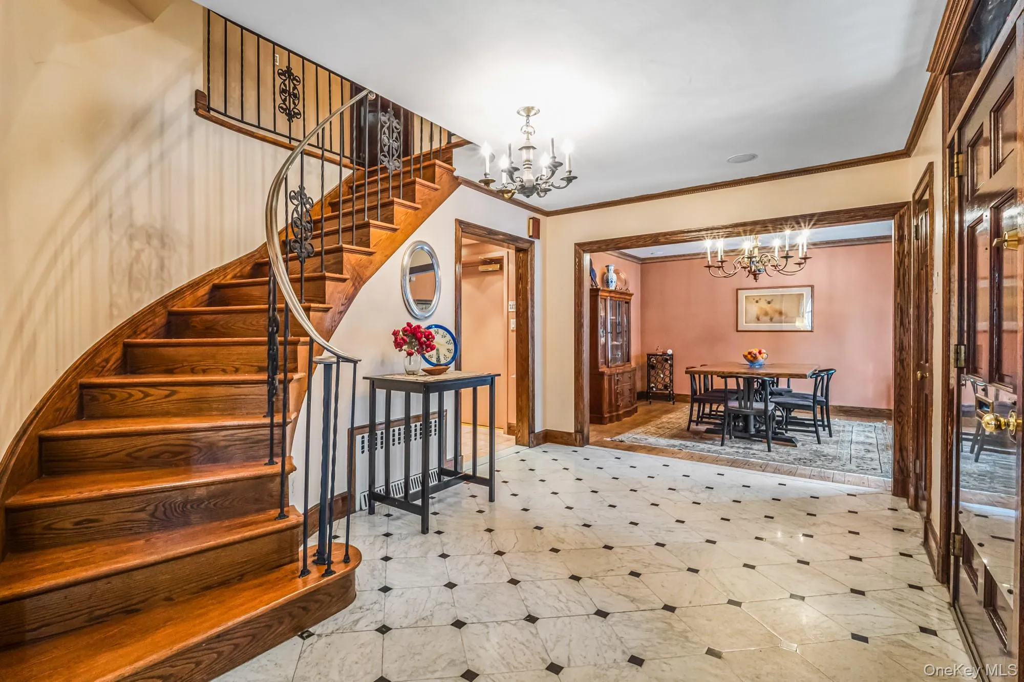 Staircase with a chandelier, crown molding, radiator heating unit, and tile patterned floors Staircase with a chandelier, crown molding, radiator heating unit, and tile patterned floors