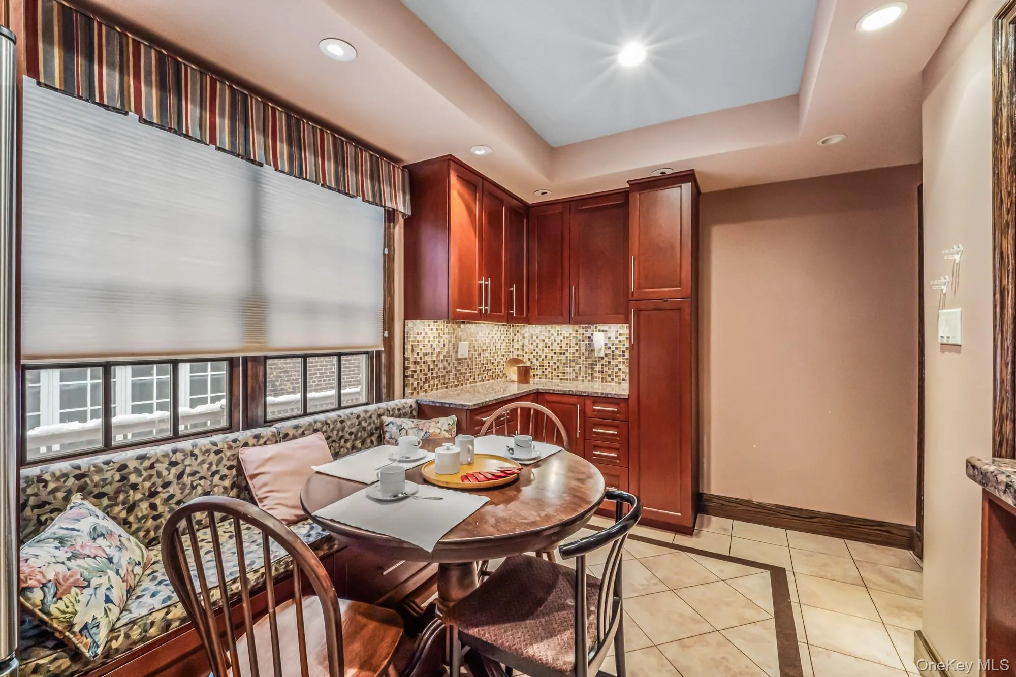Dining room with inlaid floor details, recessed lighting, light tile patterned floors, and a tray ceiling Dining room with inlaid floor details, recessed lighting, light tile patterned floors, and a tray ceiling