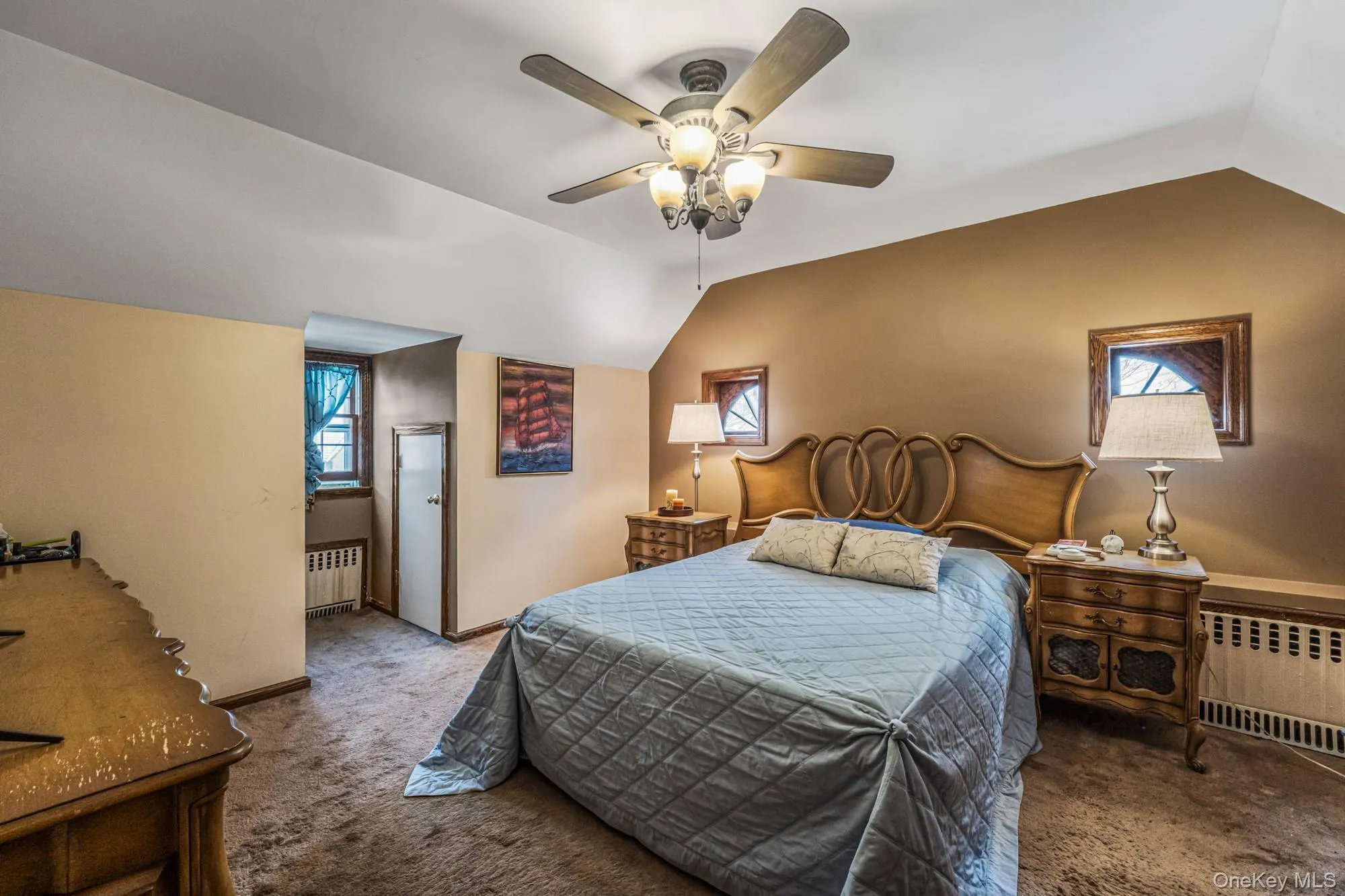 Bedroom with carpet, lofted ceiling, radiator heating unit, and a ceiling fan Bedroom with carpet, lofted ceiling, radiator heating unit, and a ceiling fan