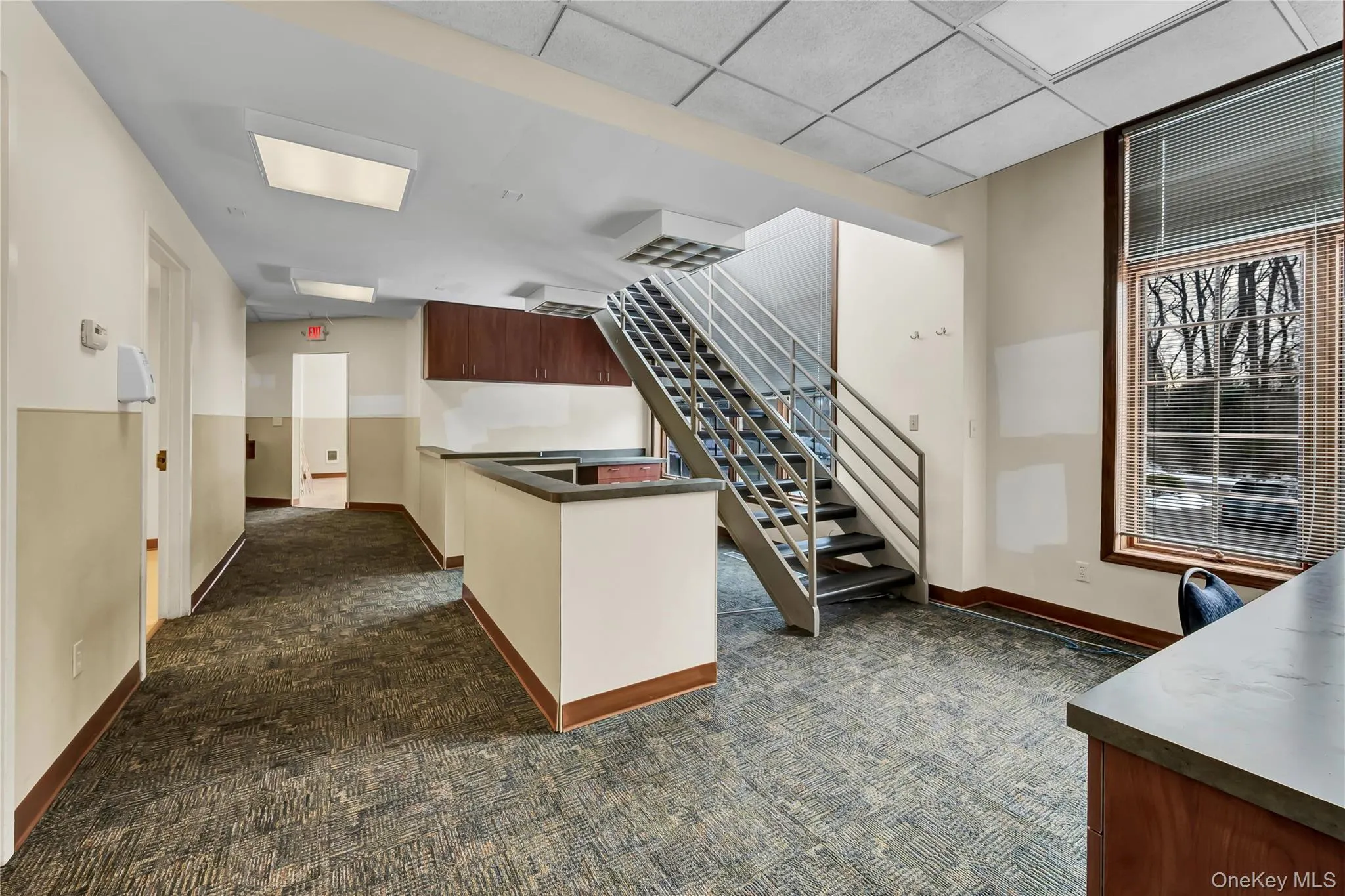 Kitchen featuring a peninsula, a drop ceiling, and dark countertops Kitchen featuring a peninsula, a drop ceiling, and dark countertops