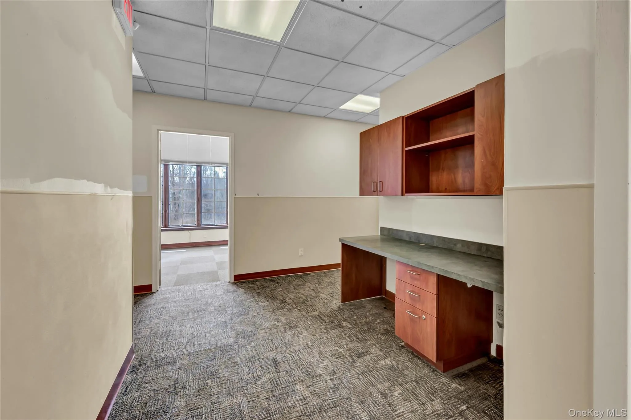Unfurnished office with built in study area and a drop ceiling Unfurnished office with built in study area and a drop ceiling