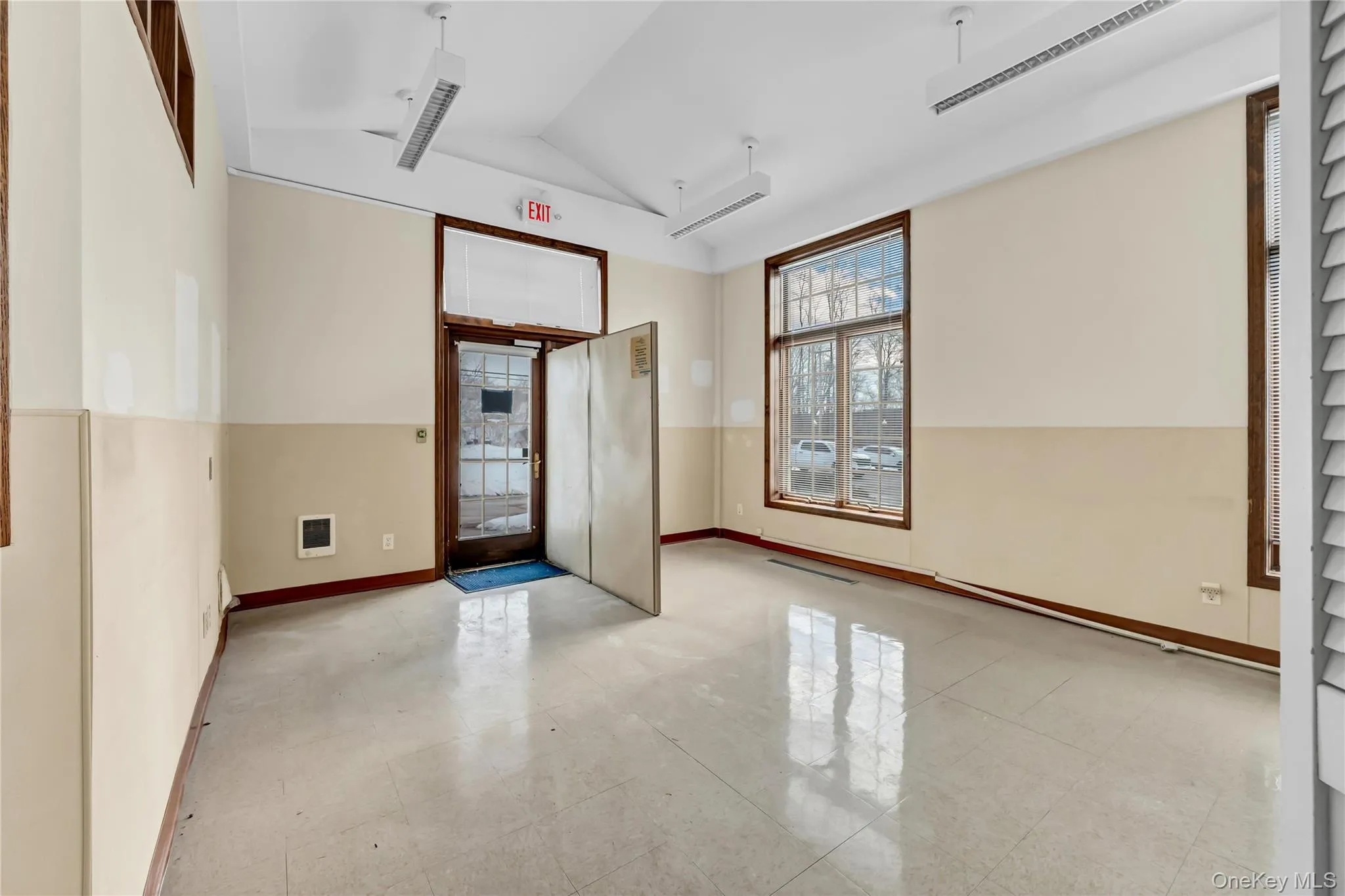 Unfurnished room featuring lofted ceiling and baseboards Unfurnished room featuring lofted ceiling and baseboards